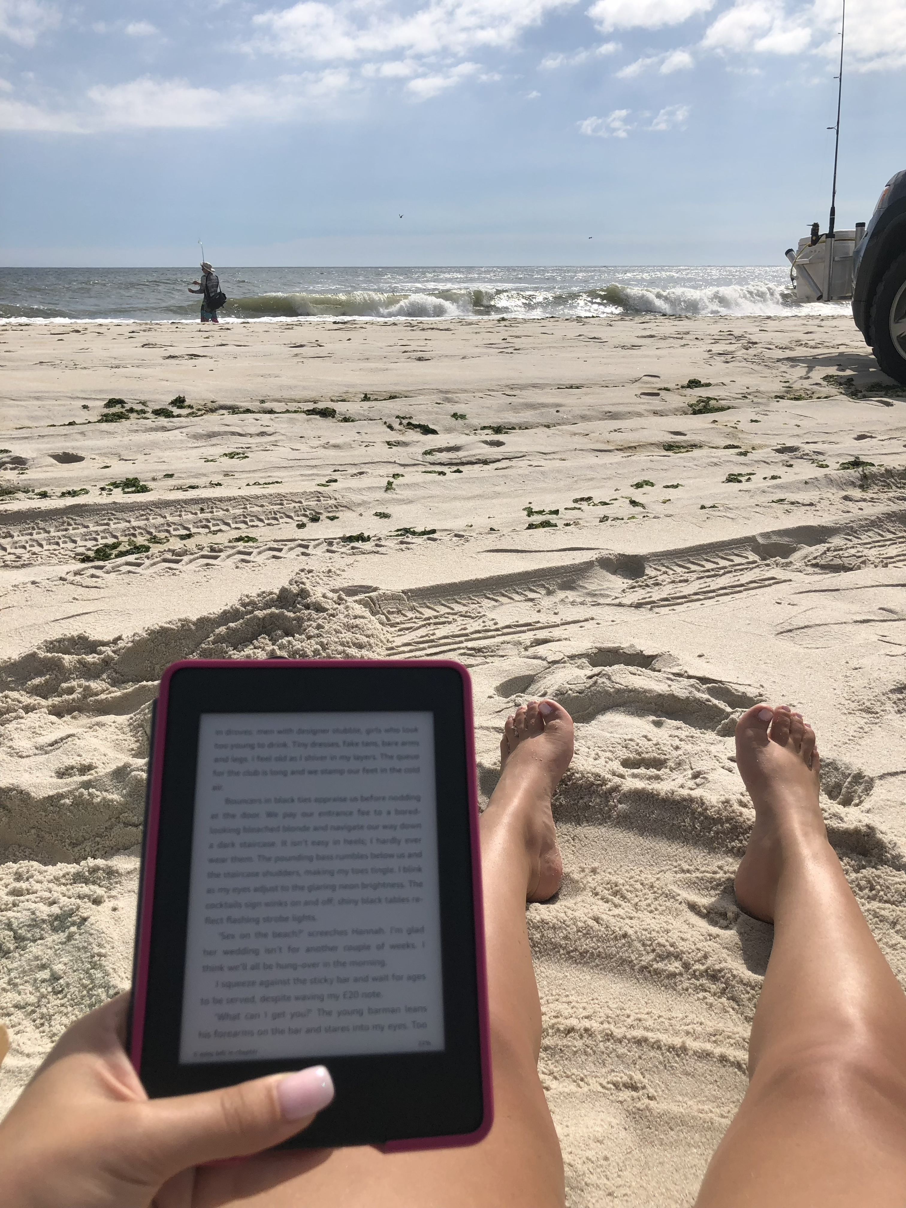 Reading by the ocean on a sunny beach.
